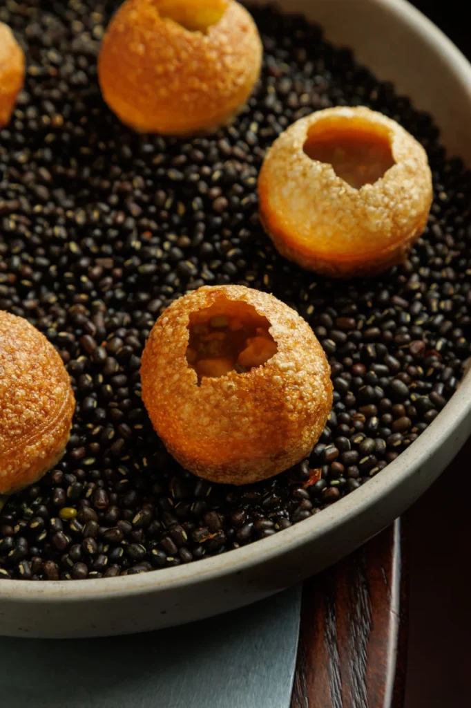 Pani puri served at Tanvi, an Indian restaurant in St George’s Bay Malta, featuring crispy shells and lentil base.